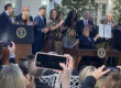 President Trump holds up his Executive Order for "Advancing Women's Health to Improve Outcomes in All Phases of Life," attended by Melania Trump and leaders in his administration.